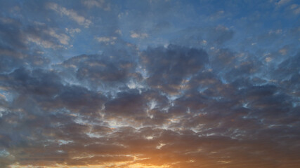 Summer evening sky in the picturesque clouds, lit by the rays of the setting sun.