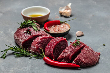 Beef medallions with rosemary and spices, Raw beef meat steak Tenderloin fillet on a dark background. banner, menu, recipe place for text, top view