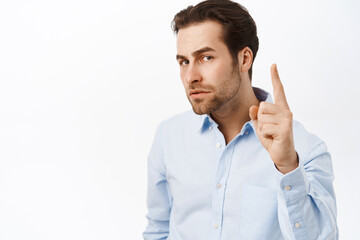 Serious businessman shakes finger and looks concerned, disapprove smth, prohibit action, scolding...