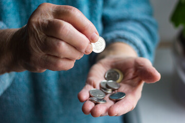 Grandma's wrinkled hands hold change in poverty