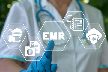 Medicine, information technology, healthcare concept. Nurse using virtual touchscreen presses abbreviation: EMR. EMR Electronic Medical Records.