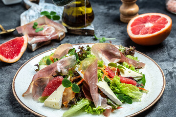 Prosciutto crudo ham salad with brie camembert cheese and grapefruit, salad mix