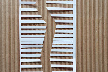 cut paper shape with stripes or fringes on corrugated paper background
