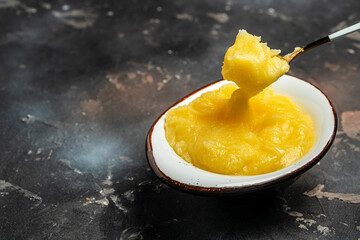 Homemade Melted ghee clarified butter. Bio Ayurveda Lactose free high quality butter on a dark background. place for text