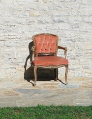 Outdoor bergere chair background.  Empty armchair seat.  Vintage style furniture in front of a wall.  