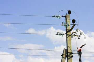 Electric poles with wires against the sky with clouds. The idea of providing electricity to the...