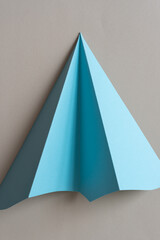 folded paper triangle isolated on beige