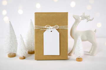 Christmas gift tag party favor thank you card mockup, styled with white reindeer and mini trees,...