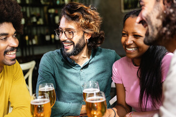 Happy multiracial business colleagues having a drink after work at brewery bar