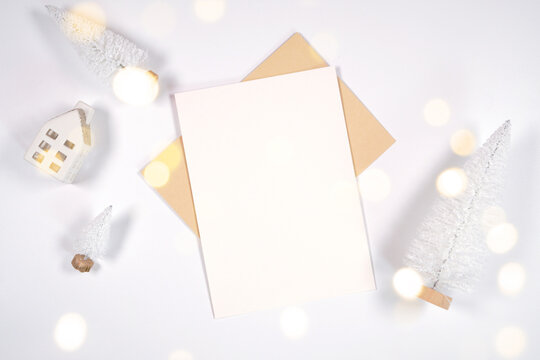 Christmas 5x7 greeting card, party invitation mockup, styled with white reindeer and mini trees, bokeh party fairy lights on a minimalist white background.