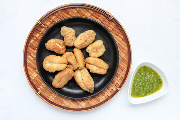Fried squid eggs. frilled delicious squid eggs served with spicy sauce on white wooden table. Thai...