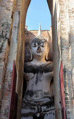 A Buddha statue at Wat Si Chum in the precinct of Sukhothai Historical Park. UNESCO World Heritage Site in Thailand.