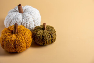 Knitted pumpkins on an colorful background, autumn composition.