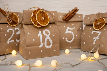 Handmade Advent calendar from craft paper with dry oranges and cinnamon
