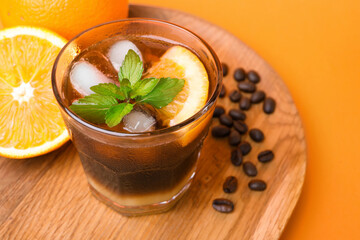 Tasty refreshing drink with coffee and orange juice on bright color background