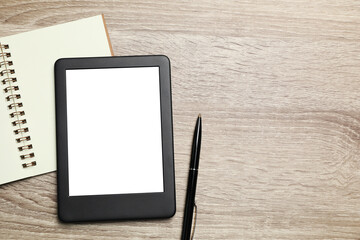 E-book reader with notebook and pen on wooden table, flat lay. Space for text
