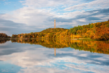 reflection of trees in the lake with an obelisk at high point state park