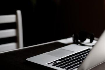 Defocus workspace mockup on dark background. Home work place with laptop. Freelance, working from home, online learning, studying, home office concept. Out of focus