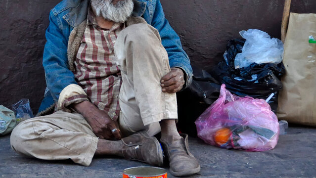 Vagabundo espera paciente ayuda de las personas en Guanajuato, México.