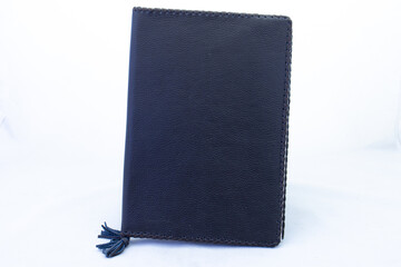 A book with a black leather cover isolated on a clear background with copy space