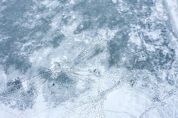 frozen lake ice texture with many different footprints. aerial drone photo looking down.