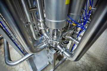The process pipe valve is stainless at the in-process area of the pipeline flowing stainless food milk in a factory at the control room