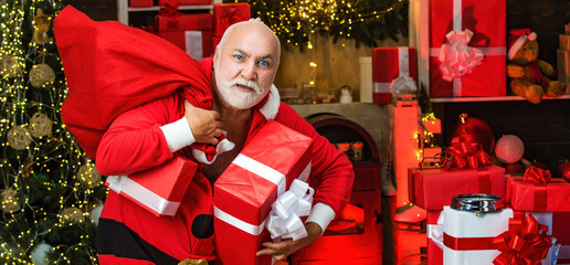 Criminal Santa posing with a steal bag of christmas gifts. Bad santa concept. Funny bad Santa Claus...