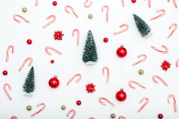Christmas background with decorations and candies on white background, top view
