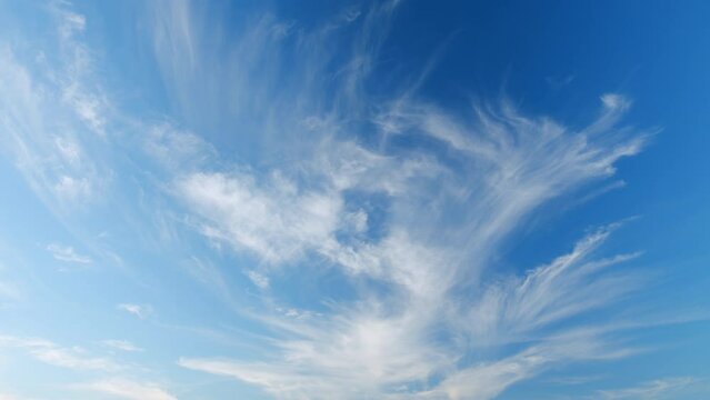 Cirrus clouds flying slowly on beautiful blue sky horizon background. Timelapse.