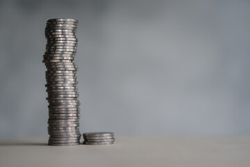 Coins arranged vertically on wood plank background , Saving and growing business concept, selective focus. Concept of revenue growth