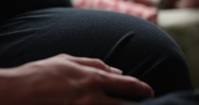 Expecting mother pokes pregnant belly - extreme close up on baby in belly