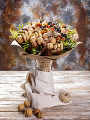 Gift bouquet of natural nuts and dried fruits. Ideas for original handmade gifts. Sweet healty nutrition. Vertical shot. Copy space