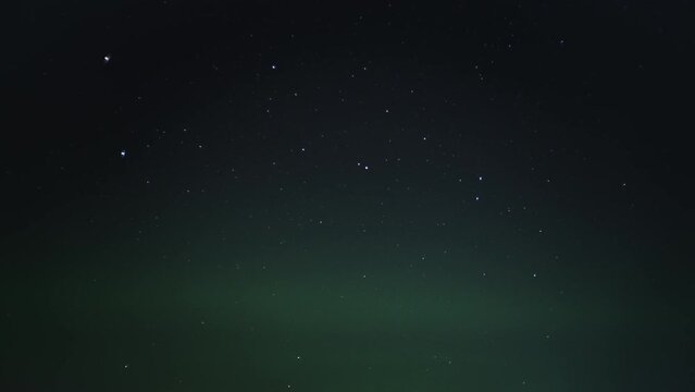 Northern Lights (Aurora Borealis) shining on the starry night sky. 