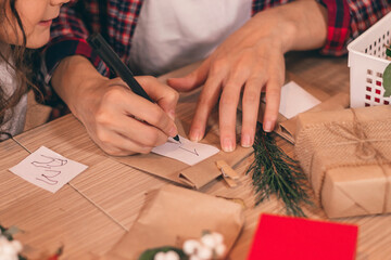 Mother and daughter making an Advent calendar,preparing for Christmas and New Year,packing and decorating gifts at home.Upcoming holidays and celebrations.Selective focus,hands close-up.