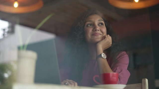 Happy Young freelance business Indian woman working at laptop in coffee shop , online conference distance office chat, Working from cafe, Working remotely and Self learning at cafe.