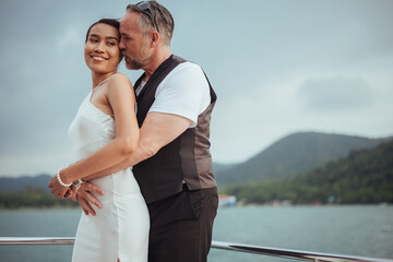 Romantic couple love hugging and kissing on yacht. Happy man and woman standing and hugging in cruise ship while sunset on vacation. luxury and honeymoon lifestyle, Happy aniversary.