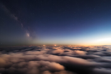 stars above cumulus clouds in the rays of the setting sun