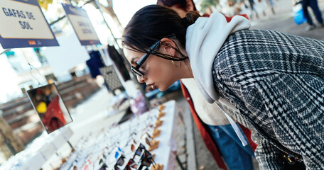 Girl looking on sunglasses at a flea market. The flea market. Madrid