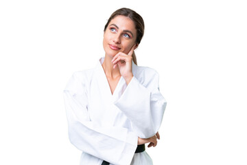 Young Uruguayan woman doing karate over isolated background having doubts and thinking