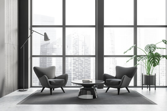 Grey meeting room interior with two seats and coffee table, panoramic window
