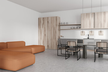 Light studio interior with couch and dining area, cooking area with kitchenware