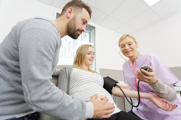 Obraz premium pregnant couple in ultrasound examination measuring blood pressure