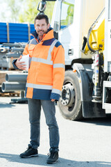 portrait of man wearing high visibility jacket and holding hardhat