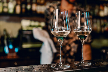 Two glasses of cold dry white wine on bar