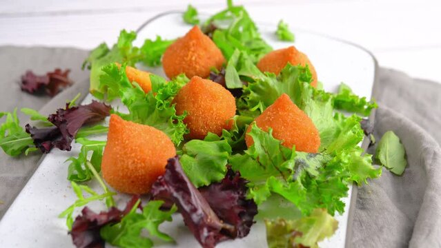 Spinning video of Traditional fried coxinha de frango - croquette of chicken on the white table, Brazilian snack.