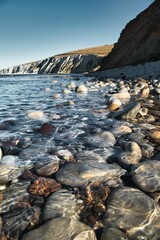 Vertical shot of a rocky beach and a cliff in Isle of Wight, England