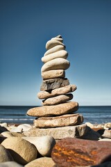 Vertical shot of a rock balancing on a beach in Isle of Wight, England