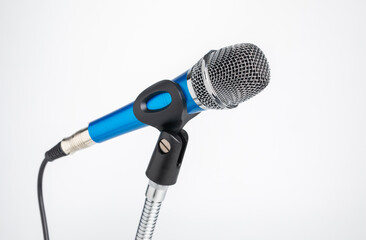 Close up of blue microphone with cable on stand isolated on white background.