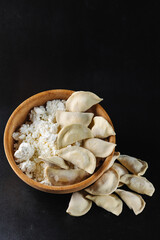 Traditional Russian dumplings vareniki with cottage cheese on white background with sour cream, butter and greens. Dish of Russian national cuisine. Side view