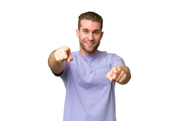 Young handsome caucasian man isolated on green chroma background pointing front with happy expression